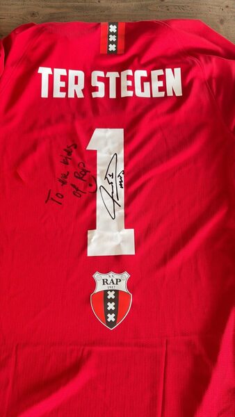 Gesigneerd rood RAP-shirt met naam Ter Stegen en nummer 1, met de tekst To the kids of RAP