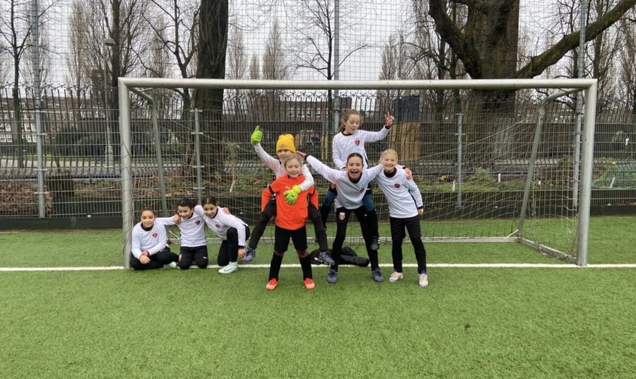 Speelsters van RAP MO12-1 poseren vrolijk voor het doel